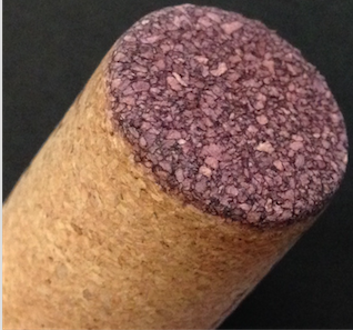 Close-up of the end of a micro-agglo cork showing fissures between cork bits where the plastic seems to have dissolved. Photo from a recent purchase by this article's author.